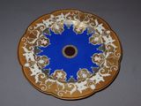 a blue and gold plate with a flower design on it