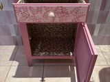 a pink cabinet with a drawer on top of it