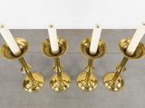four candles are lit in a row on a table