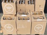 Des caisses de bière sont empilées sur une palette devant un mur noir