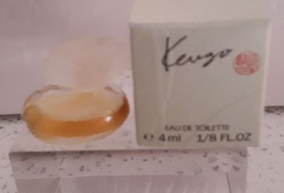 un flacon de parfum posé sur un comptoir à côté d'un beignet
