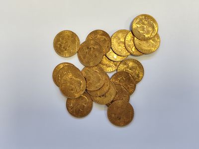a close up of a pile of gold coins on a white surface