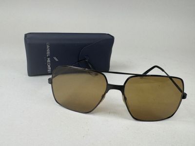 une paire de lunettes de soleil posée sur une table, à côté d'un étui