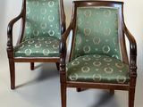 pair of green upholstered chairs with wooden arms and arms