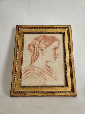 an old picture of a woman with braid hair in a gold frame