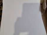 une feuille de papier blanche dans une boîte, avec l'ombre d'une personne