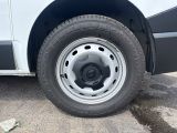 a white van with a flat tire parked in a parking lot