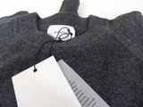 a gray sweater with a tag on it on a white table