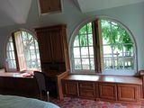 une chambre avec un lit, un bureau et des fenêtres
