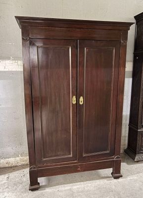 une armoire en bois qui se trouve à côté d'une vieille horloge