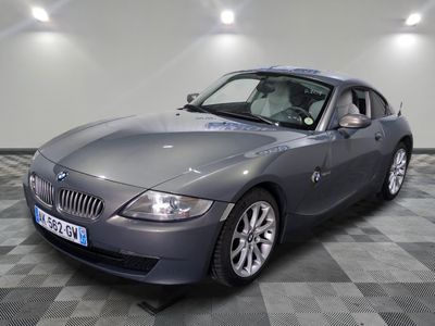 une photo d'une voiture de sport grise garée dans un garage