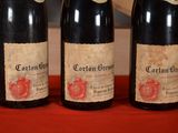 three bottles of wine are lined up on a red cloth