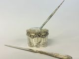 a silver spoon and a silver container with a spoon in it