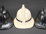 three helmets are lined up in a row on a gray surface