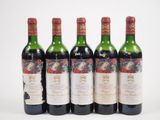 quatre bouteilles de vin sont alignées sur une surface blanche