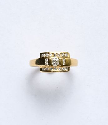gros plan d'une bague en or avec des diamants sur une surface blanche
