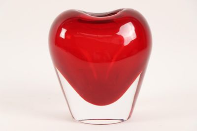 a glass vase with a red heart inside of it