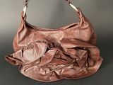 an image of a brown purse with a bow on the handle