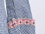 a close up of a blue and white checkered shirt hanging on a clothes rack