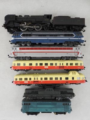 cinq trains de couleurs différentes posés sur une surface blanche