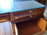 a wooden desk with a glass top and drawers