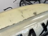 a white surfboard sitting on top of a black rack