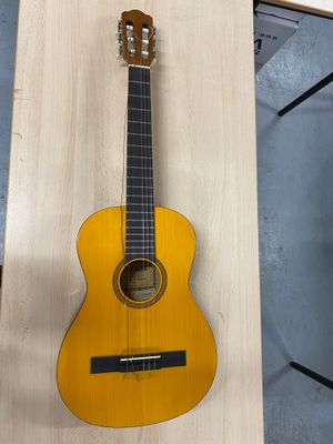 une guitare acoustique accrochée au mur d'une pièce