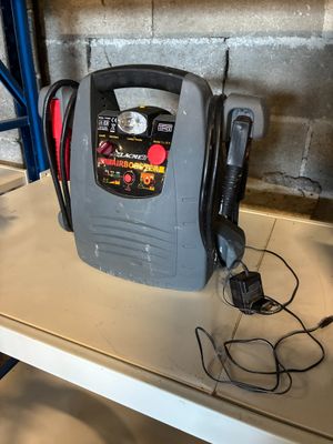 un petit compresseur d'air posé sur une étagère dans un garage