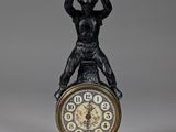 une statue représentant un homme au sommet d'une horloge