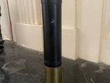 a black and gold cylinder on the floor next to a white door
