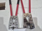 two red and black wire clamps attached to a white board