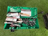 une boîte verte remplie d'outils posée sur l'herbe