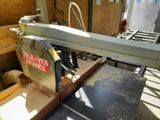 a machine that is cutting a piece of wood on a table