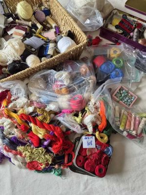 un panier rempli de laine et d'autres objets posé sur une table