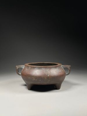 an old brown pot sitting on top of a table next to another pot