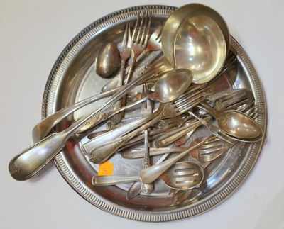 de nombreuses cuillères et fourchettes en argent posées sur un plateau en argent