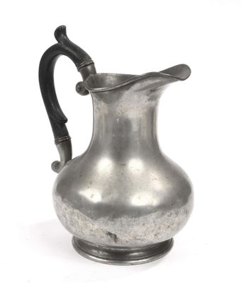 a silver pitcher that is sitting on a white surface