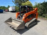 un gros plan sur une petite porte orange en forme de ski garée sur un parking