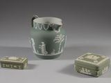 un vase vert et deux petites boîtes posées sur une table