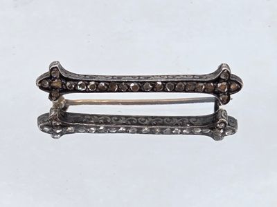 a close up of a pair of silver hair clips on a white surface
