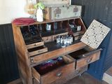 an old wooden desk with a lot of bottles on it