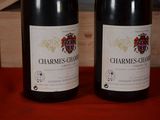 two bottles of wine sitting on a table next to each other
