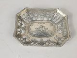 une image représentant une assiette en argent sur laquelle figure le portrait d'une femme