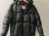 the jacket is hanging on a hanger on the wall