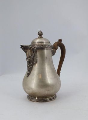 an antique silver coffee pot with a handle on a white background