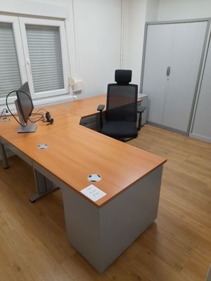 a desk with a computer and a chair in the room
