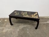 a small black table with a floral design on it