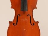 un vieux violon posé sur une table près d'un mur blanc