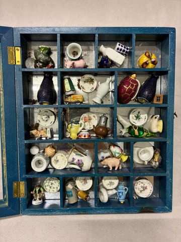 Dans une boite vitrine vaisselle de poupée, fèves