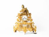 une horloge en or posée sur une table blanche